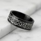 A polished black zirconium wedding ring featuring a contrasting engraved silver-toned Celtic eternity knot pattern, cast against a white background with a reflection below.