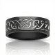 A polished black zirconium wedding ring featuring a contrasting engraved silver-toned Celtic eternity knot pattern, cast against a white background with a reflection below.