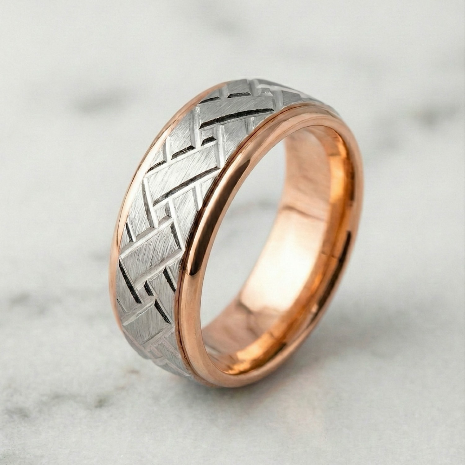 Close-up of a men's custom wedding ring. The band is 6mm wide with a two-tone construction. The outer rails and interior are high-polish 9k yellow gold. The center channel features a white gold insert with a matte satin finish and a deep-etched diagonal b