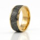 The Strata Wedding Ring: A polished yellow gold band featuring a central inlay of laser-carved black zirconium with a wavy woodgrain pattern, standing on a white background.